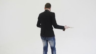 Siyah ceketli, sakallı, vahşi bir adam. Parmak ucunda ahşap bir tabanca çeviriyor. Şık, şık, güler yüzlü bir adam ofis savaşına hazırlanıyor. Modayı takip eden kovboy taklidi yapar. Komik bir durum.