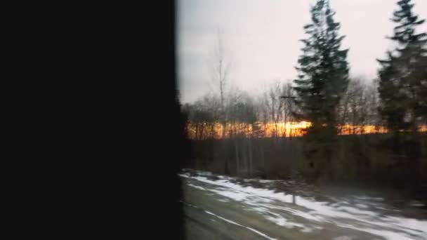 Prachtige oranje zonsondergang tijdens het rijden op de trein, uitzicht vanuit het raam. Natuur en bossen, achtergrond. Voorjaar — Stockvideo