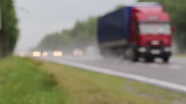 Um grande tráfego de carros dirige em uma estrada rural com os faróis acesos em tempo chuvoso outono molhado. Segurança rodoviária na estrada com pouca visibilidade. Espaço de cópia para texto, embaçado — Vídeo de Stock