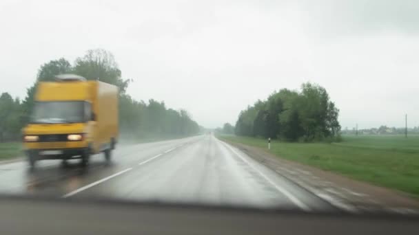 車からの交通が運転している雨の国の道路への車からの眺め。悪天候の概念、テキストのコピースペース — ストック動画