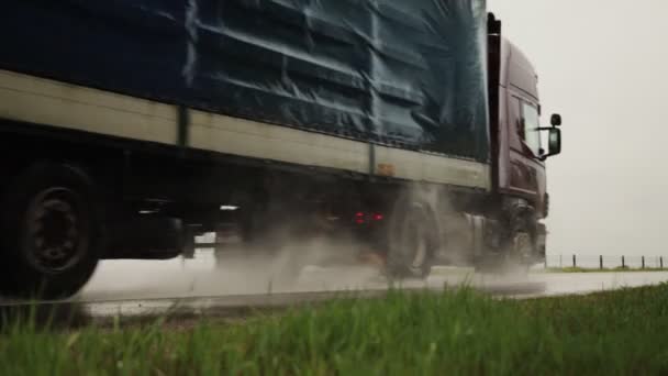 A félpótkocsi félpótkocsi nyáron nedves úton szállítja a rakományt az esőről, közelről. Csúszós út, szállítmányozási ipar. Lassú mozgás. — Stock videók