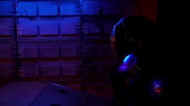 Siber punk konsepti, gelecekteki dünya. Polis yarım adam biyonik sayborg şehrin gece bölgesinde yürüyor. Bilim kurgu sahnesi, fantezi, bilim. Yarının dünyası. Neon ışıkları. Robot! Yakın çekim.