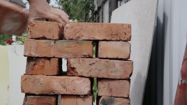 Um homem descarrega uma pilha de tijolos vermelhos, de perto. Construção — Vídeo de Stock