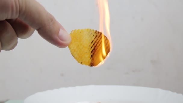 Brandende chips in een mensenhand, close-up. Junk vet voedsel concept, transvetconsumptie, fast food. Close-up — Stockvideo