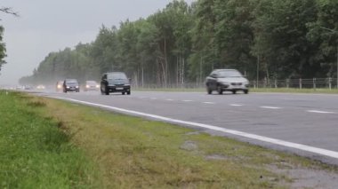 Bobruisk-Minsk Yolu, BELARUS - 2 Temmuz 2021: Yağmurlu havalarda yağmurlu bir otoyolda farlı birçok araba ve kamyon sürüyor