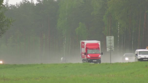 Road Bobruisk-Minsk, BELARUS - 19 Μαΐου 2021: Πολλά αυτοκίνητα και φορτηγά με προβολείς οδηγούν σε βρεγμένο αυτοκινητόδρομο με κακές βροχερές καιρικές συνθήκες — Αρχείο Βίντεο