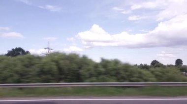 Araba penceresinden tarlalara ve çayır manzarası. Bulutlu mavi gökyüzünün arka planında güzel bir doğa. Metin için boşluğu kopyala