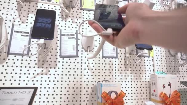 MINSK, BELARUS 30.07.20: Επιλογή και αγορά σύγχρονου τηλεφώνου και gadget. Κατάστημα ηλεκτρονικών, ψώνια, κοντινό πλάνο — Αρχείο Βίντεο