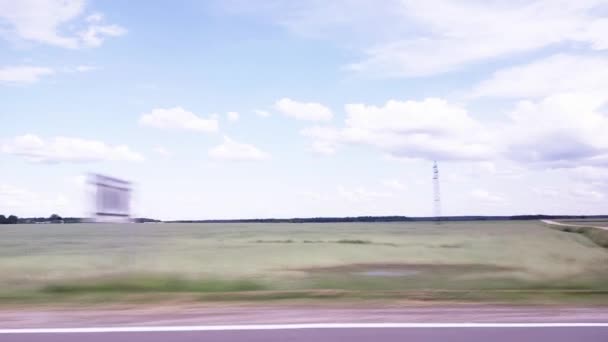 从车窗到田野和草地的景色。美丽的大自然在蓝天和云彩的衬托下.旅程，复制文字的空间 — 图库视频影像