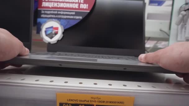MINSK, BELARUS 30.07.20: Um homem escolhe um laptop em uma loja de eletrônicos. Comprar um computador, laptop, close-up — Vídeo de Stock