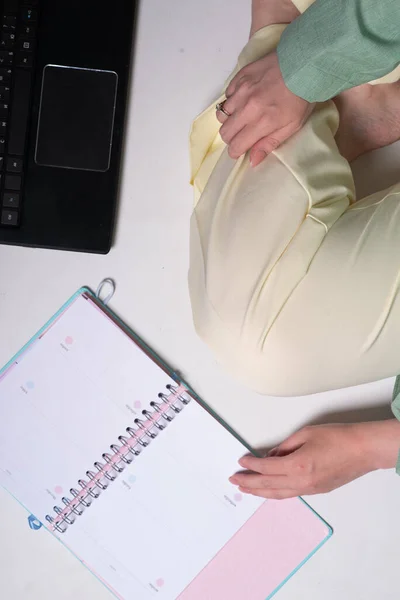 Beyaz bir kızın ellerinde defter ve defter var.