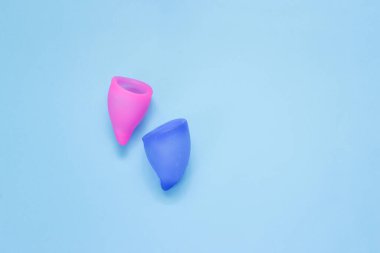 Mavi arka planda çevre dostu silikon adet bardağı. Kadın sağlığına dikkat edin..