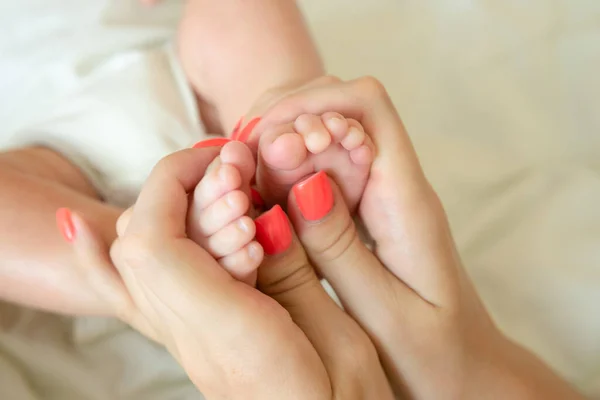 Sluit de baby 's kleine voeten in ouderhanden. ouder die pasgeborenen in armen houdt. gelukkig gezin — Stockfoto