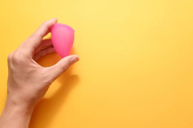 Elinde regl bardağı tutan bir kadın. alternatif sıfır atık hijyeni