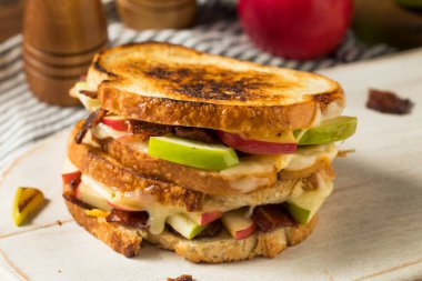 Beyaz ekmek üzerine ev yapımı domuz pastırmalı peynirli panini.