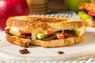 Beyaz ekmek üzerine ev yapımı domuz pastırmalı peynirli panini.