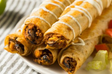Kremalı, marullu ve domatesli ev yapımı Meksika usulü tavuk flautası.