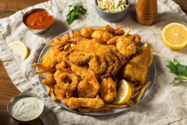 Kızarmış patates ve Tatar soslu ev yapımı kızarmış deniz ürünleri tabağı.