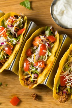 Ev yapımı sığır eti, Marul ve domatesli sert kabuklu taco.