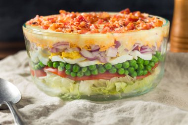 Ev yapımı yedi katlı salata, yumurta, bezelye ve marul.