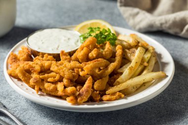Patates kızartması ve tart soslu ev yapımı midye şeritleri.