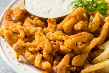 Patates kızartması ve tart soslu ev yapımı midye şeritleri.