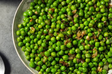 Tuzlu ve biberli ev yapımı sotelenmiş yeşil bezelyeler.