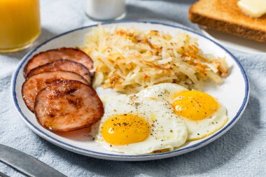 Sağlıklı ev yapımı yumurta Kanada pastırması ve kızarmış ekmekle haşlanmış kahvaltı.