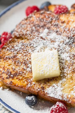 Ev yapımı Challah Fransız tostu. Pudra şekeri ve böğürtlenli.