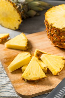 Kesme tahtasındaki organik dilimlenmiş Çiğ Ananas Düğümleri