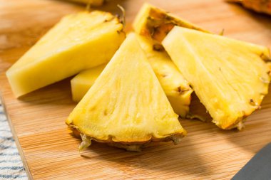 Kesme tahtasındaki organik dilimlenmiş Çiğ Ananas Düğümleri