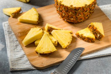 Kesme tahtasındaki organik dilimlenmiş Çiğ Ananas Düğümleri