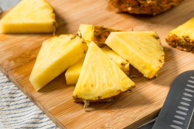 Kesme tahtasındaki organik dilimlenmiş Çiğ Ananas Düğümleri