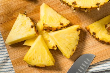 Kesme tahtasındaki organik dilimlenmiş Çiğ Ananas Düğümleri