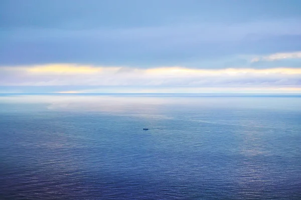 Pôr do sol rosa amarelo brilhante no céu azul e no mar . — Fotografia de Stock