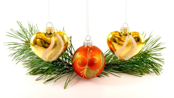 Três brinquedos de árvore de Natal pendurados perto do ramo de abeto — Fotografia de Stock