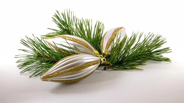 Três brilhantes cone branco em forma de brinquedos de Natal e ramos verdes — Fotografia de Stock