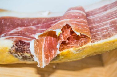 Tahta yüzeyde serrano jambonu izole edilmiş.