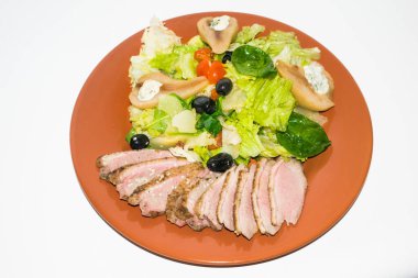 Kızarmış ördek dilimleri ve salata ve armut.