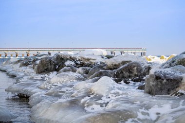 Deniz kıyısındaki taşların üstünde buz