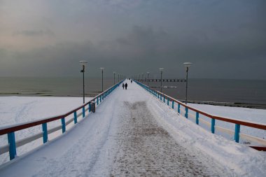 Palanga Köprüsü, kara kış gününde insanlarla ve kara bulutlarla
