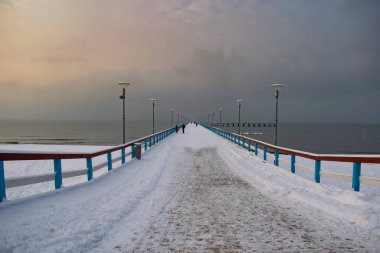 Karanlık kış gününde Litvanya, Palanga 'da insanlarla köprü.