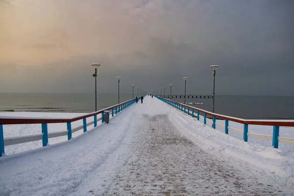 Karanlık kış gününde Litvanya, Palanga 'da insanlarla köprü.