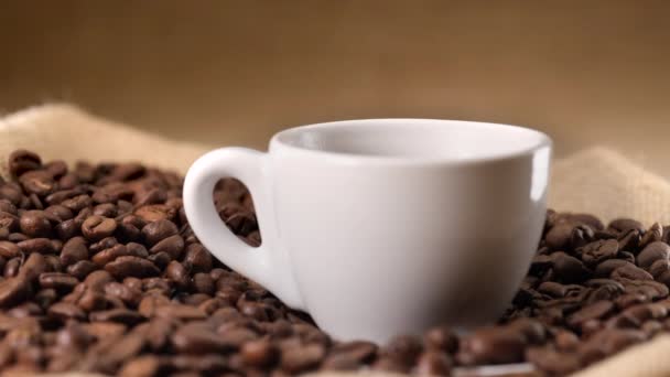 Gorąca Parująca Filiżanka Kawy Jutowym Tle Ziarna Kawy — Wideo stockowe
