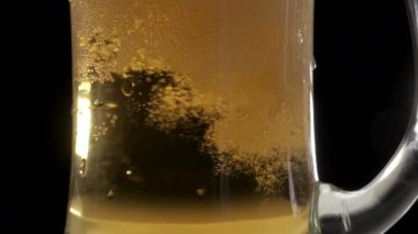 Sarı bira bardakta sallanır.