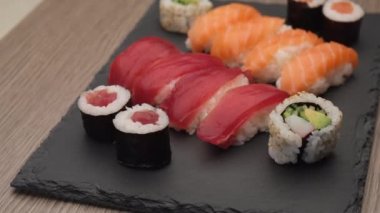 Sushi assortment with nigiri salmon, nigiri tuna, hosomaki and uramaki. Typical Asian food rotating on a plate