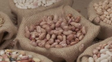 Dry Borlotti beans falling on jute bowl in slow motion. Mediterranean diet vegetarian vegan ingredient healthy food