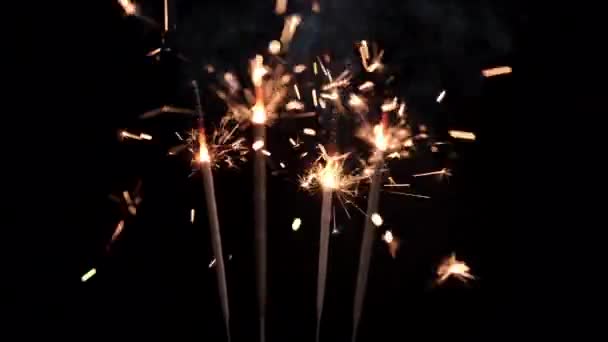 大晦日のお祝い クリスマスパーティーのために黒を背景に燃える輝く花火 — ストック動画