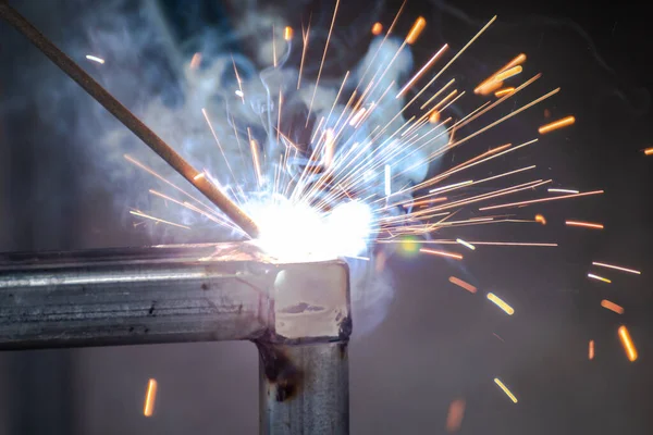 welder and welding sparks, construction and metal work industrial concept, metal welding with sparks, laborer or labor day concept