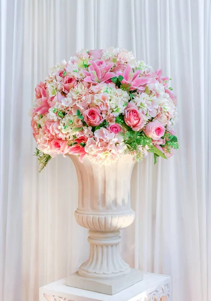 Çiçek buketi vazonun üzerinde düğün süsü olarak duruyor.